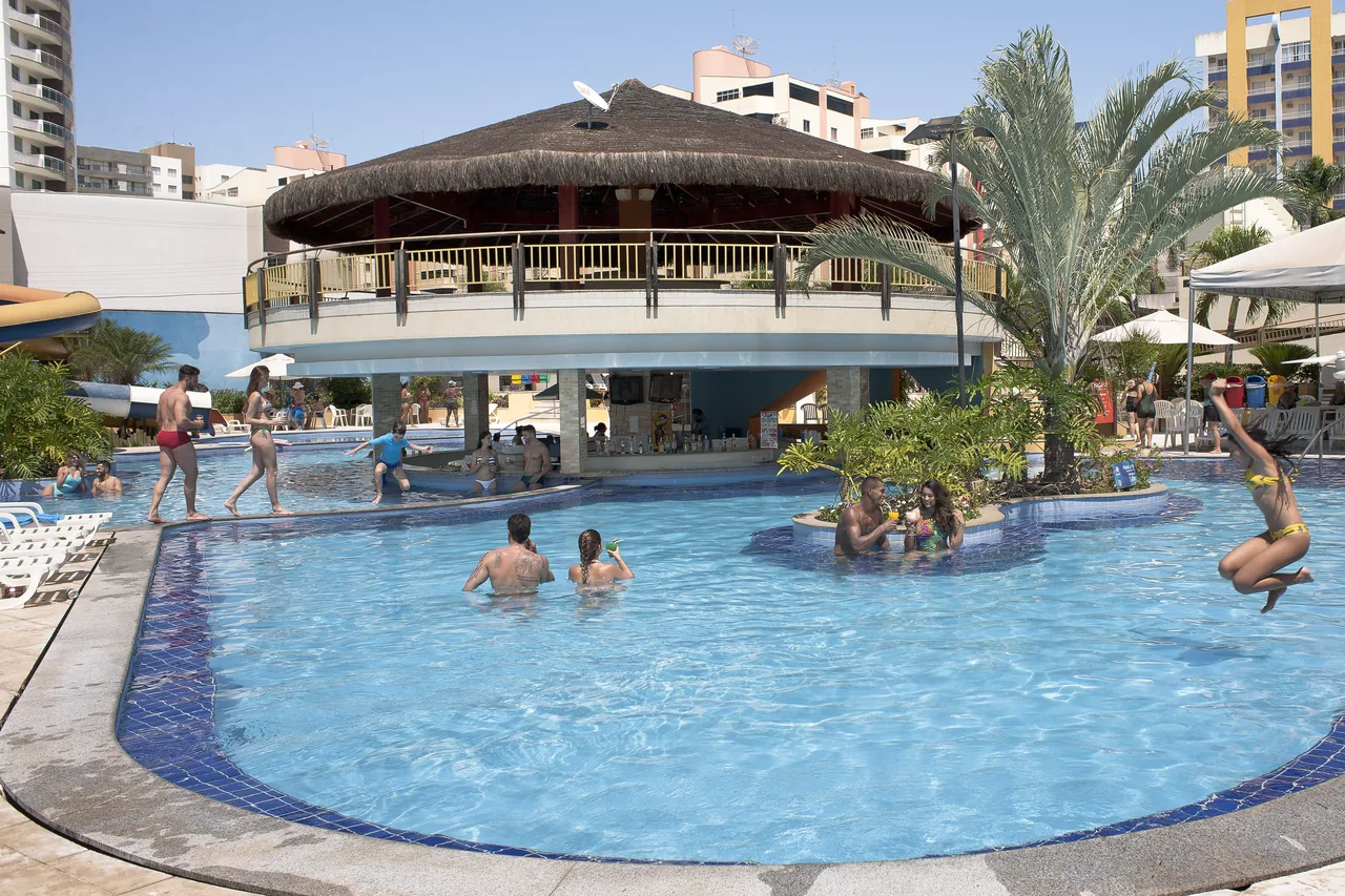 Piscina com bar central e palhoça do Clube Privé